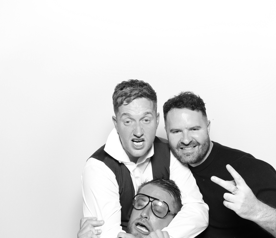 B&W image of 3 guests posing  in a funny way for a wedding party entertainment in the cotswolds
