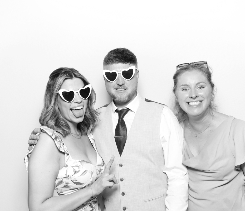B&W image of guests posing for a premium photo booth rental at Ivy Lodge wedding venue Cirencester
