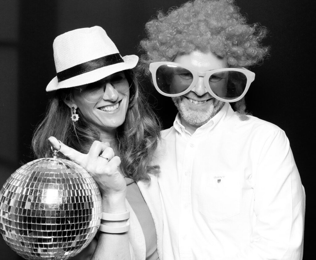 couple using really fun props and disco balls, during a stroud wedding at painswick hotel , with the kardashian style photo booth rental 
