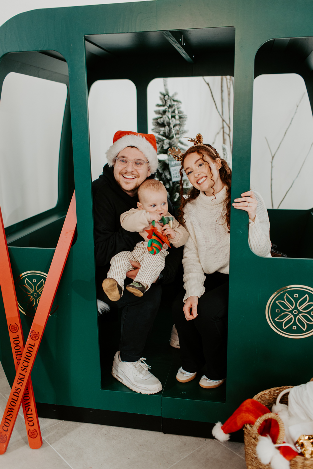 Close up of Family posing in an apres ski themed photo booth at Cotswolds Designer Outlet with festive props and instant prints