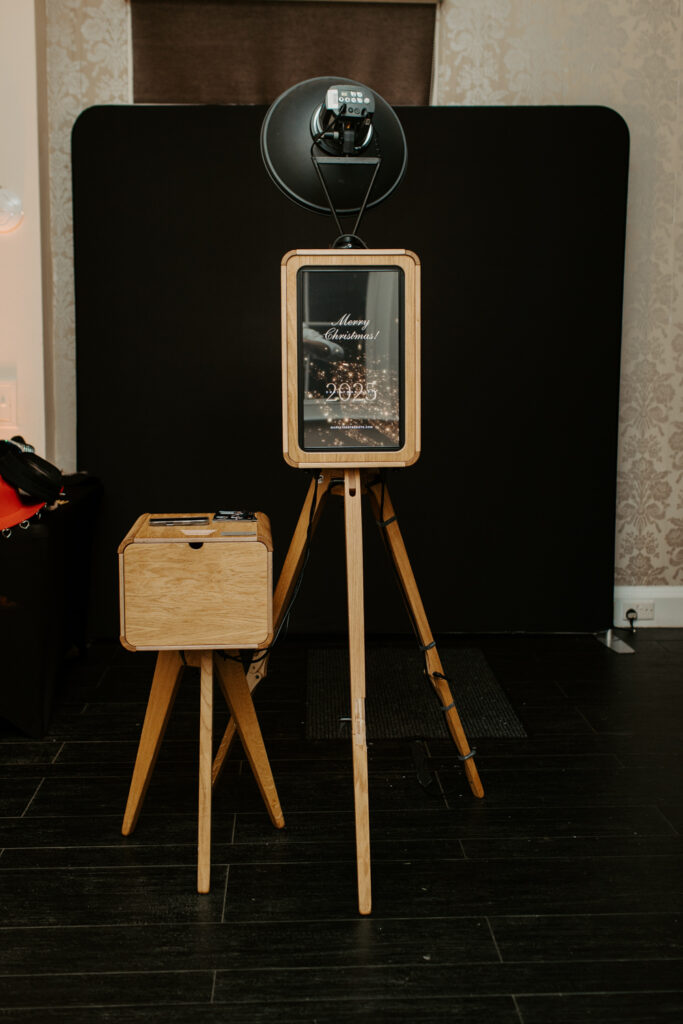 Full photo booth setup with printer stand and black backdrop at a company Christmas party, ready for guests to use at botleys mansion
