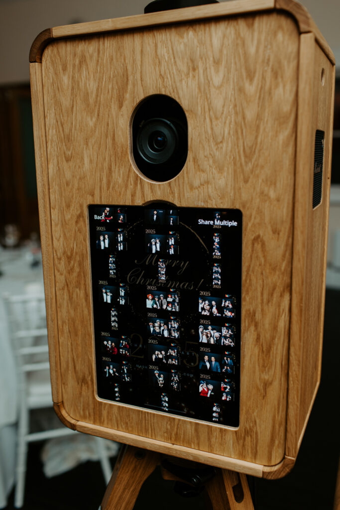 Front view of the Icon photo booth with prints samples display on the screen, set up for a festive company event at botleys mansion
