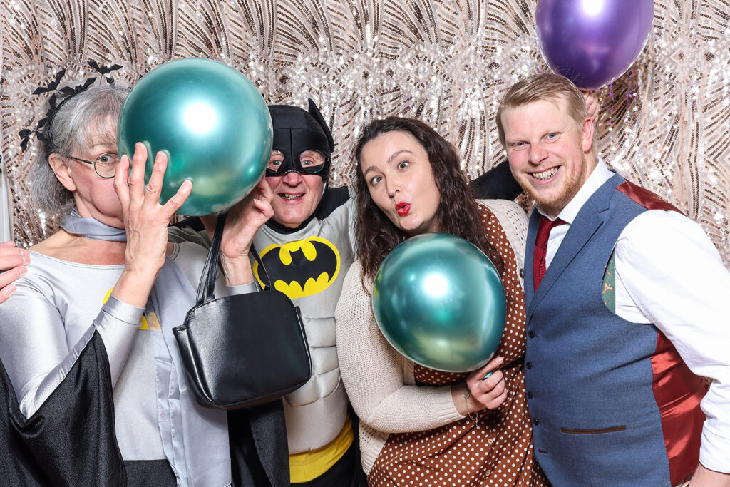 dressed up guests having fun and posing with balloons for a 40th birthday party photo booth hire in the cotswolds, with mad hat photo booth rental