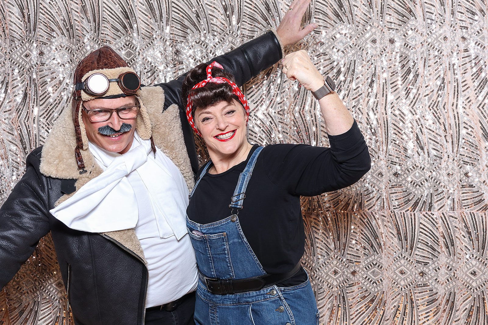 group of friends dressed up for an 1940s birthday party theme, with balloons and a sequins backdrop