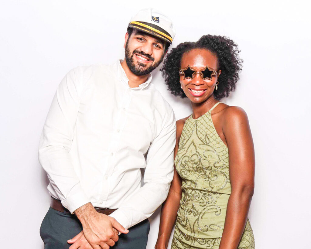 2 guests posing against a white backdrop for a cheltenham selfie pod rental, using an affordable photo booth hire

