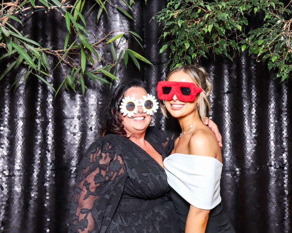 2 guests posing against a black backdrop during a corporate event entertainment in Gloucester