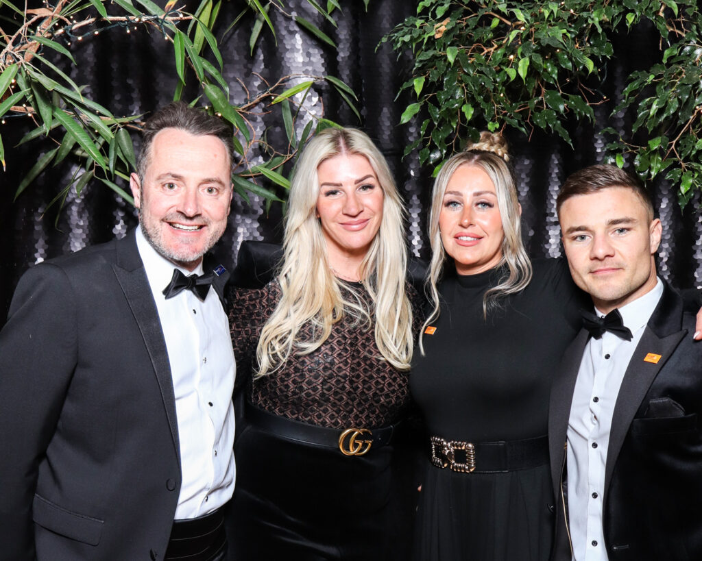 4 guests posing against a black backdrop during a corporate event entertainment in Gloucester
