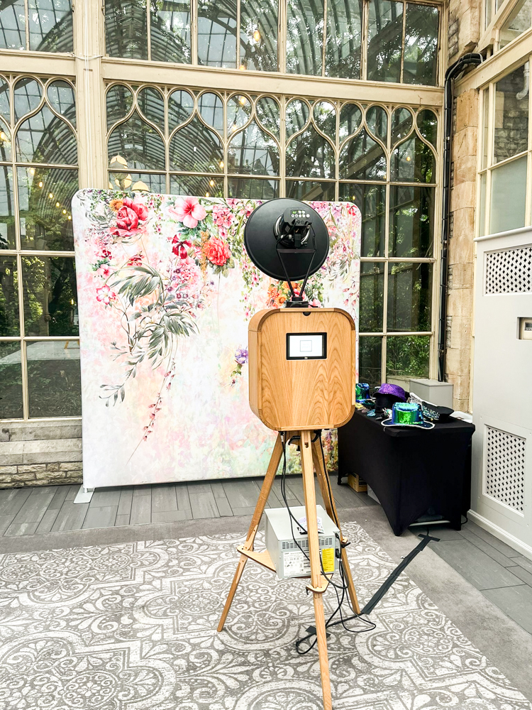 Retro photo booth setup with a floral pillow backdrop during a wedding party reception at de Vere wedding venue 
