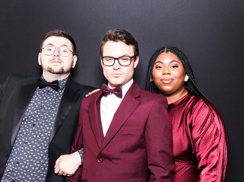 3 guests dressed elegantly during a Charity Gala Photo Booth Hire event entertainment posing against a black backdrop for a professional image during a corporate event4