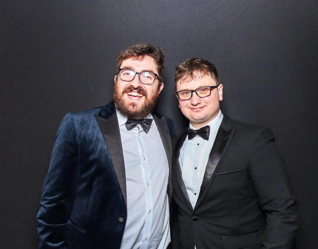 2 guests dressed elegantly during a Charity Gala Photo Booth Hire event entertainment posing against a black backdrop for a professional image during a corporate event4