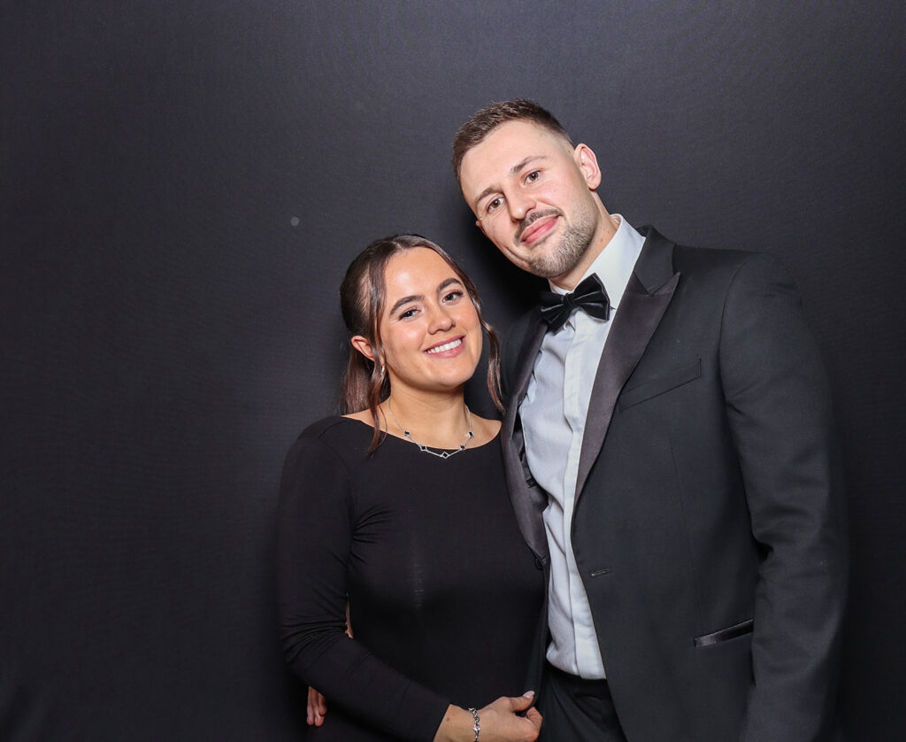 2 guests dressed elegantly during a Charity Gala Photo Booth Hire event entertainment posing against a black backdrop for a professional image during a corporate event4