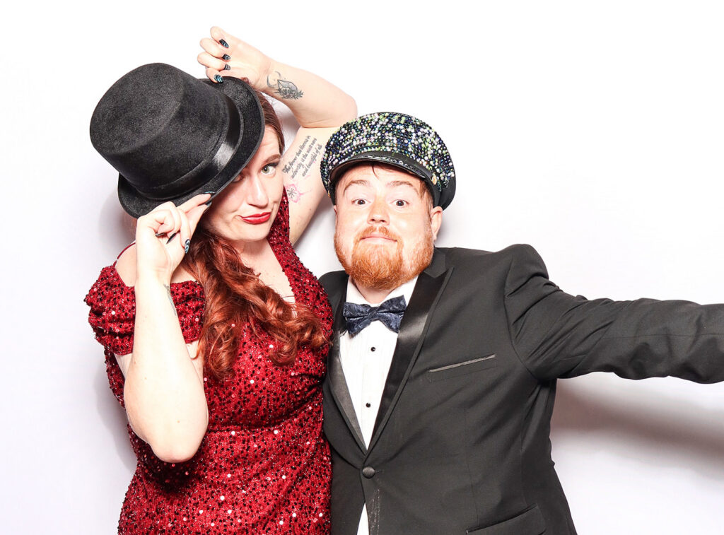 fun classic photo booth image of guests wearing props dressed in black tie posing against a white backdrop for a Corporate Photo Booth Hire Oxfordshire 