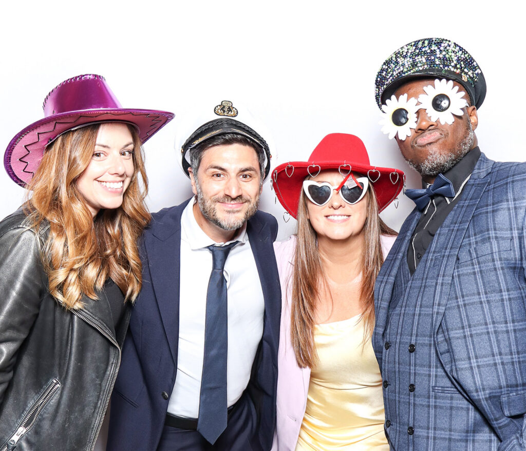 fun classic photo booth image of guests dressed in black tie posing against a white backdrop for a Corporate Photo Booth Hire Oxfordshire 