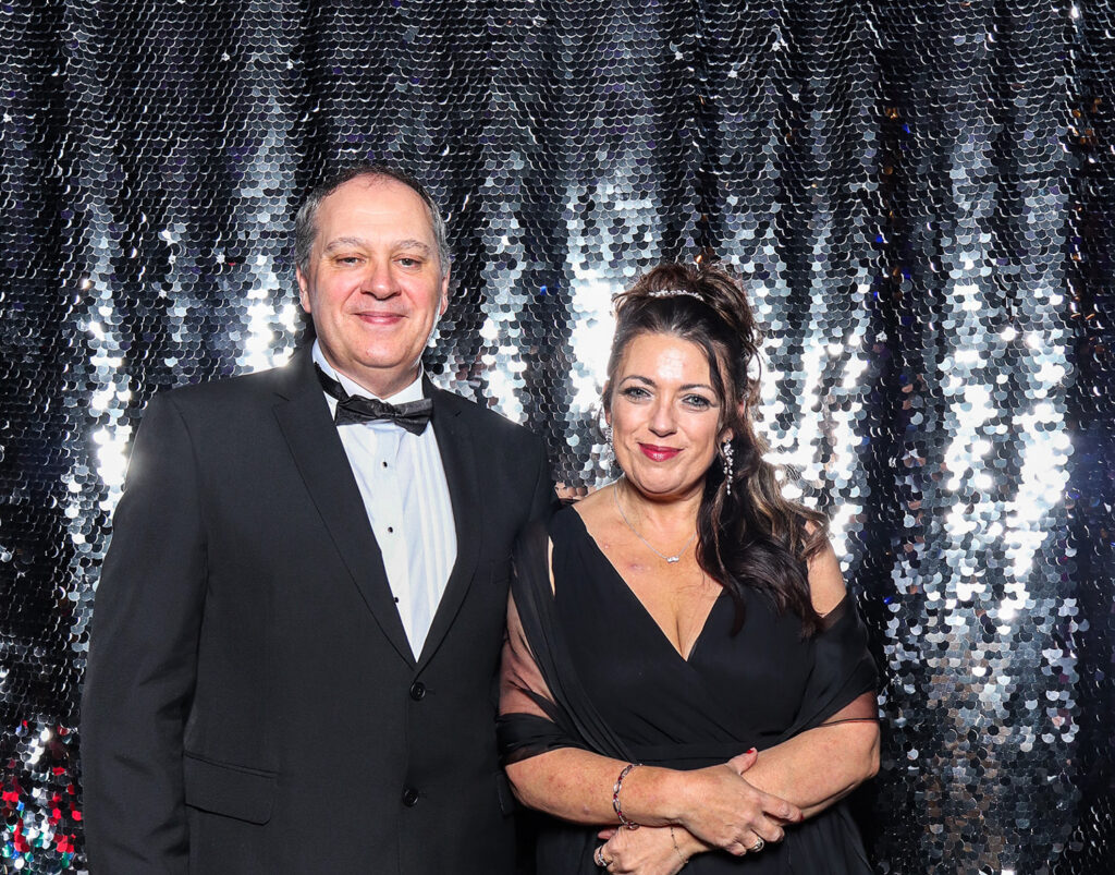 2 guests posing against a silver sequins backdrop for a Corporate Photo Booth Hire Oxfordshire , during an a conference event
