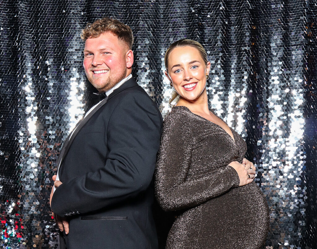 2 guests posing against a silver sequins backdrop for a Corporate Photo Booth Hire Oxfordshire , during an a conference event entertainment

