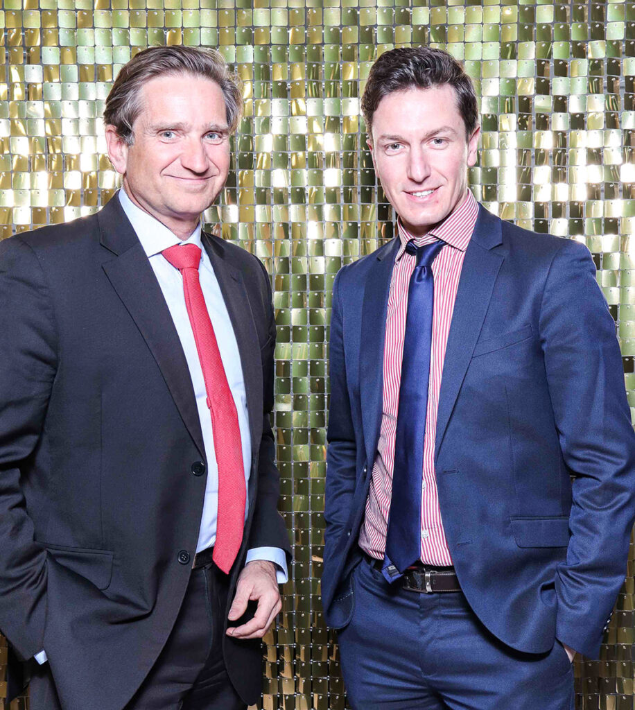 Luxury Corporate Photo Booth Rental in Oxfordshire with guests posing against a gold shimmer backdrop during an awards dinner