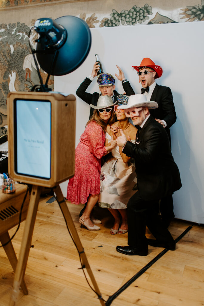 Guests using the photo booth at an Owlpen Manor wedding