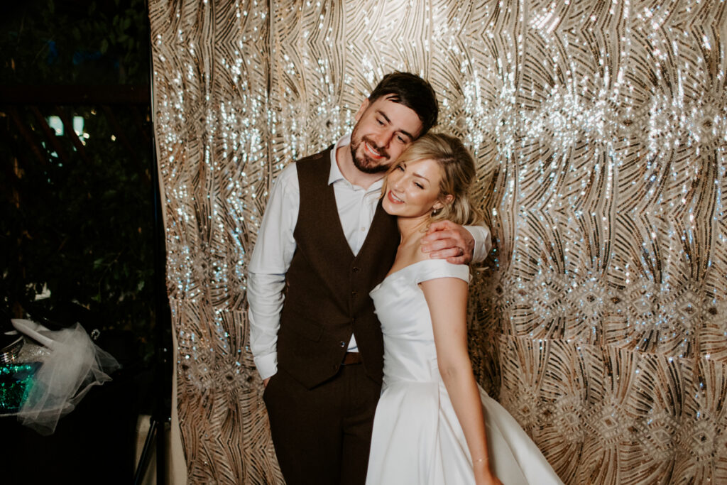 bride and groom pose during a photo booth hire at stone barn cotswolds wedding venue during a party reception entertainment hire
