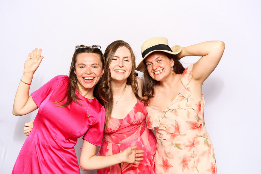 asian guests posing for a photo booth hire, against a white backdrop during a 2-day wedding party entertainment at Grittleton House wedding venue, in Wiltshire 