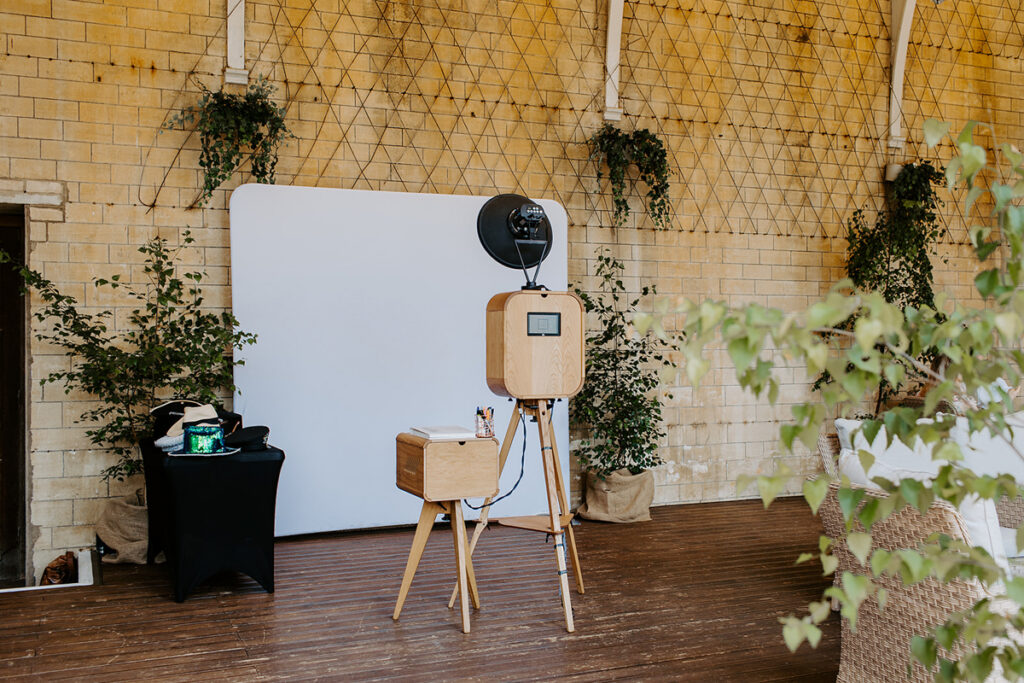 Retro photo booth setup with props, and white backdrop for an outdoor garden party at Grittleton House wedding venue in Wiltshire 
