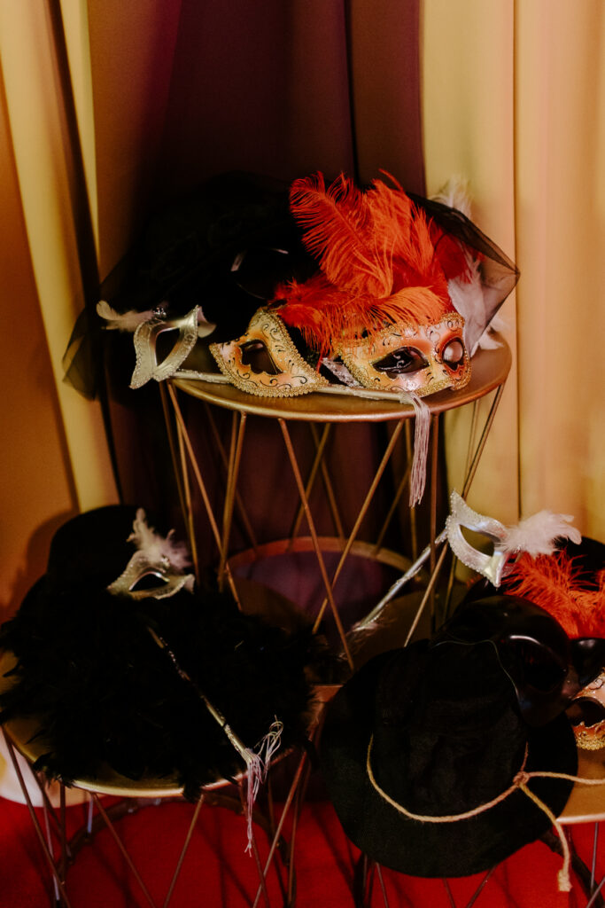 circus themed event photobooth props and masks for guests posing against a circus style backdrop and themed props