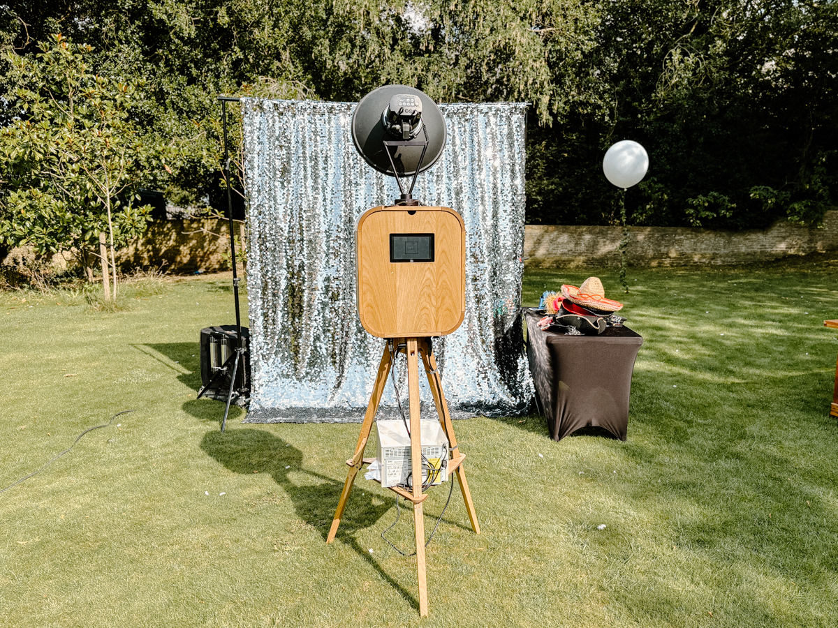 Outdoor wooden photo booth with silver sequin backdrop at a private birthday party at Soho Farmhouse.