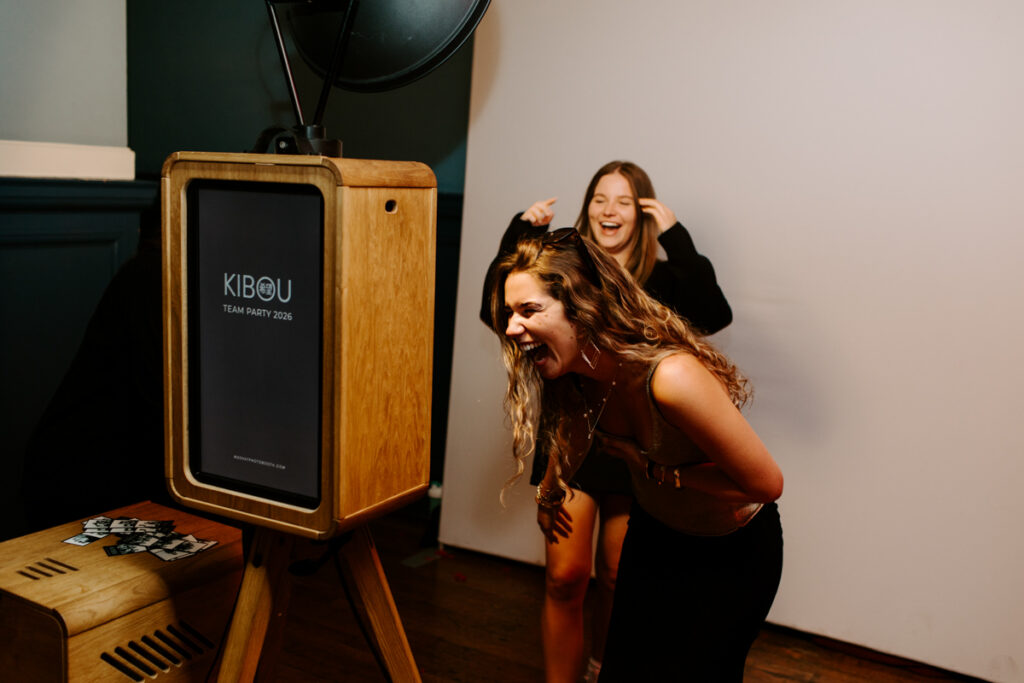 2 ladies laugh really hard while posing for a premium photo booth during a corporate event 