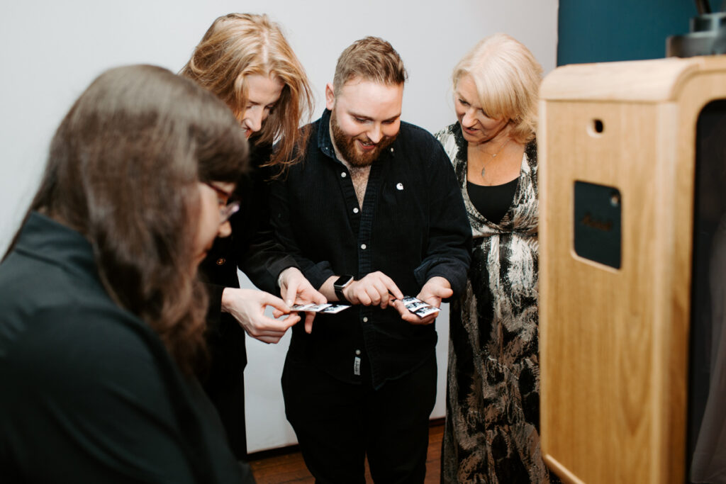 guests checking prints during an Oxford Town Hall event entertainment for Corporate Events with the icon premium photo booth hire for Kibou restaurant team party 
