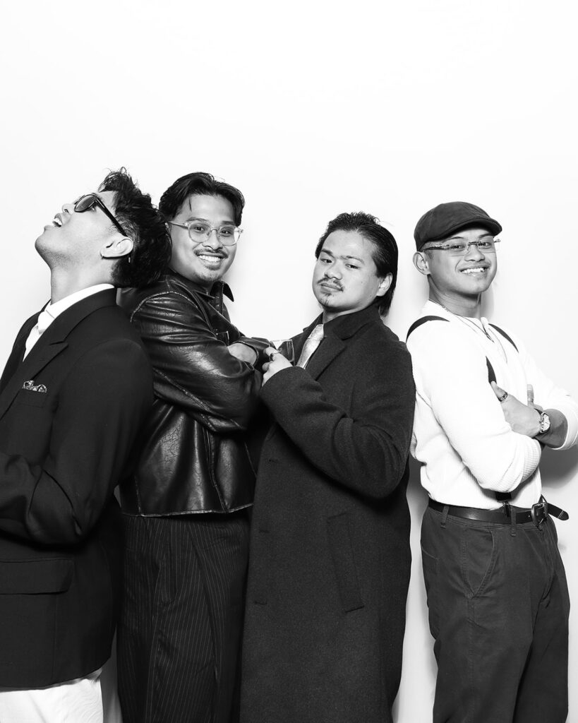 b&w image of 4 guests posing against a white backdrop, during a corporate event party entertainment with mad hat photo booth hire in oxfordshire