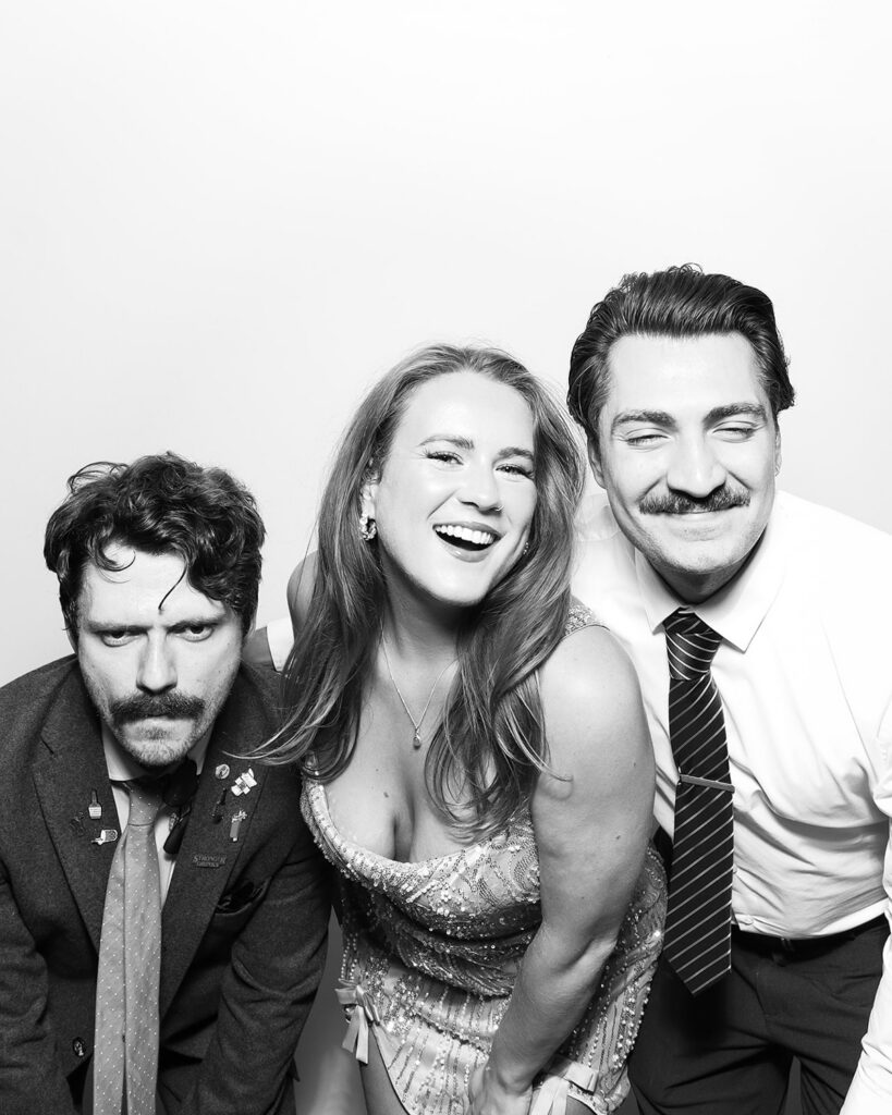 b&w image of 3 guests posing against a white backdrop, during a corporate event party entertainment with mad hat photo booth hire in oxfordshire