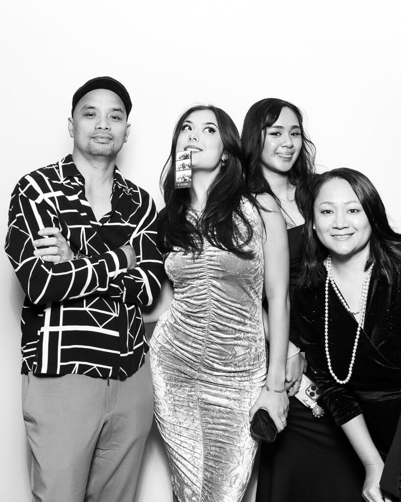 b&w image of 4 guests posing against a white backdrop, during a corporate event party entertainment with mad hat photo booth hire in oxfordshire
