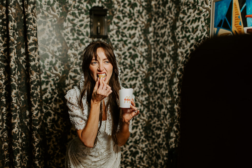 bride posing eating chips for a retro photo booth hire during a private party at coombe end manor in cheltenham