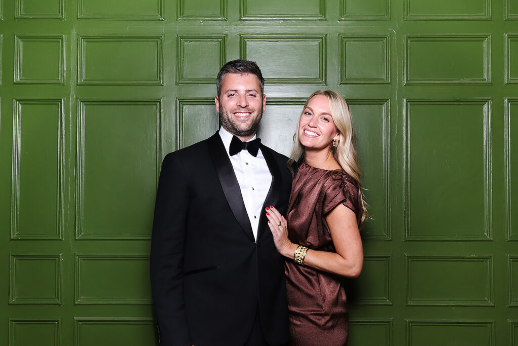 couple posing the green wall at dumbleton hall wedding venue during the wedding party entertainment

