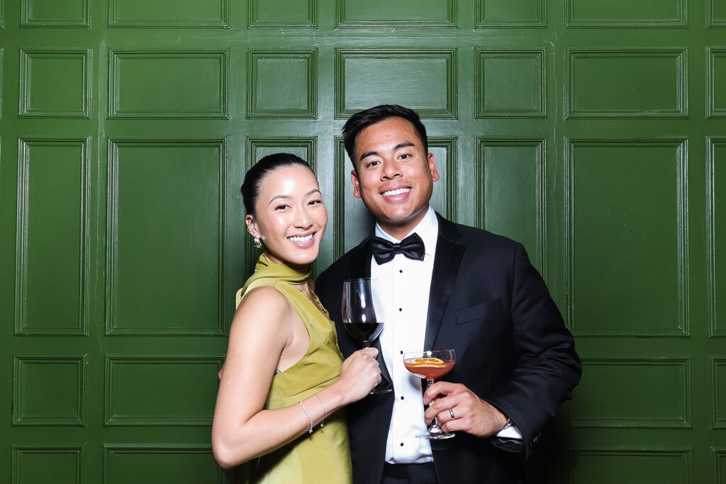 couple posing the green wall at dumbleton hall wedding venue
